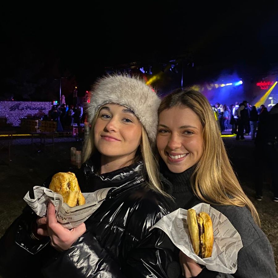 Dos clientas con hamburguesas de Q Street Food en un festival nocturno